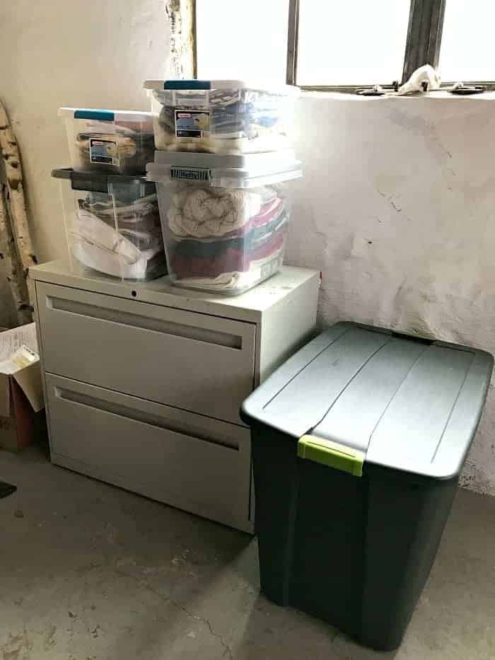 bins of throw pillow covers on file cabinet in basement