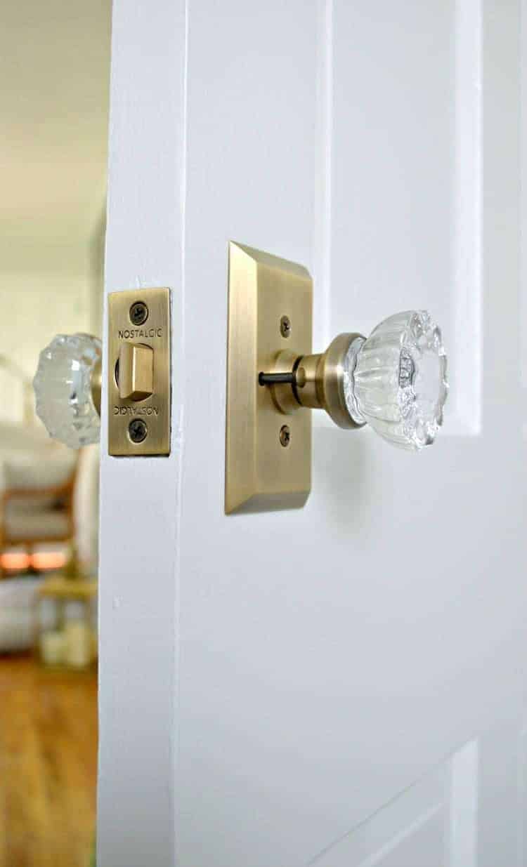 view of lock on new brass and glass door knob on bathroom door