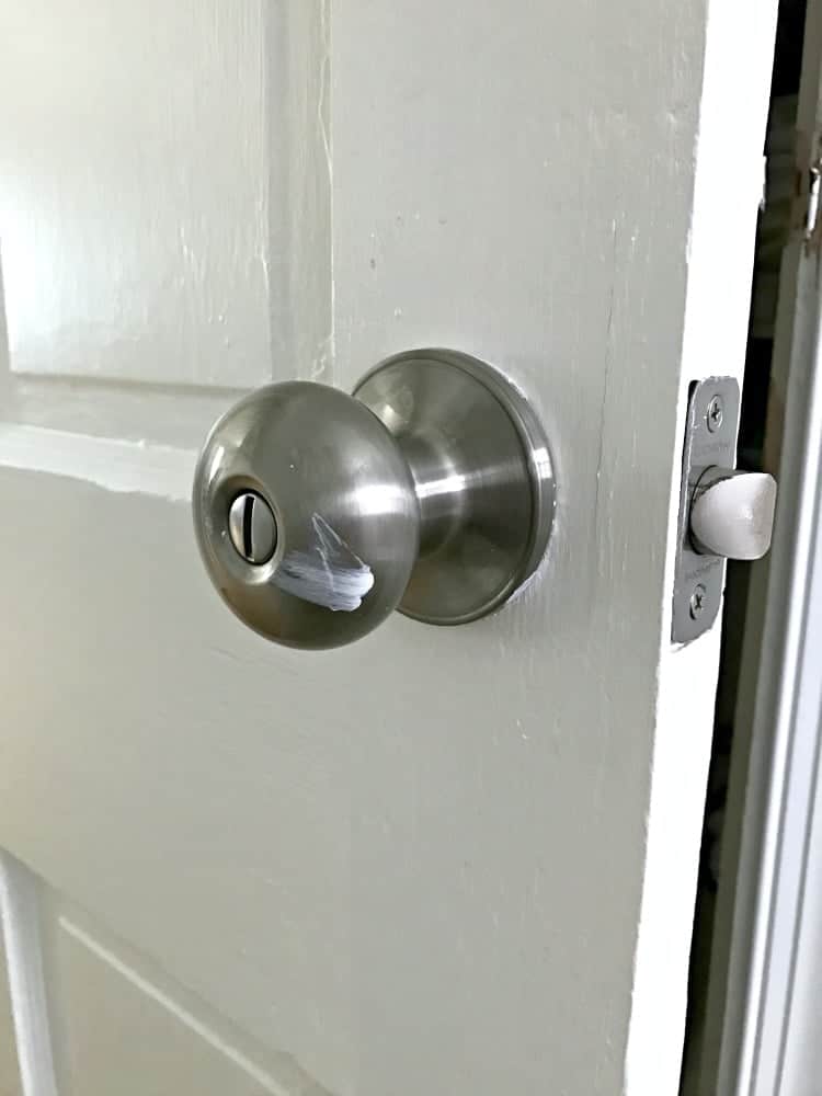 old door knob on door with paint smear