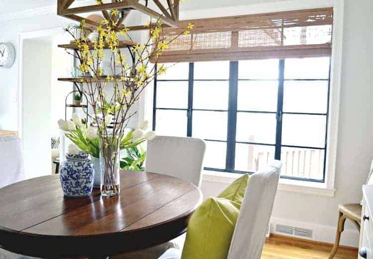 A dining room filled with furniture and vase of flowers on a table