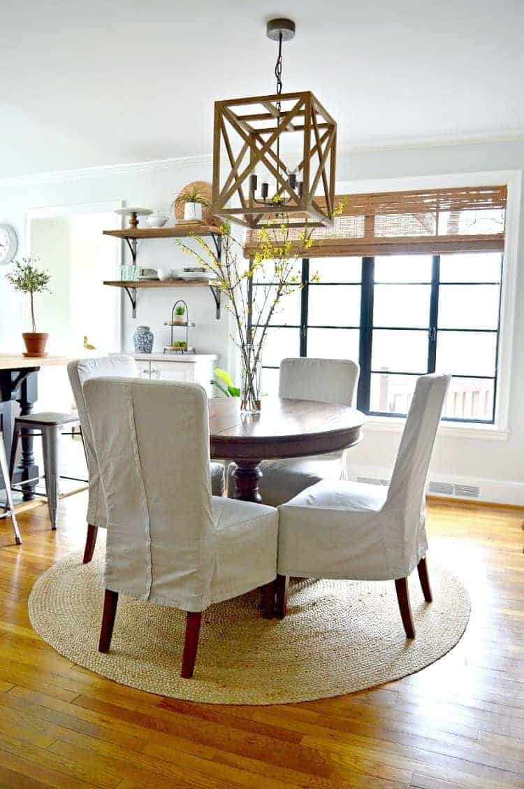 small dining room makeover with round wood table and 4 chairs on jute rug