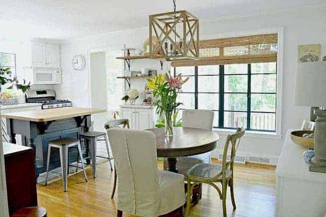 small dining room with round table, 4 chairs and black painted window