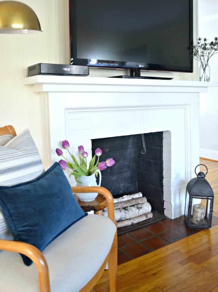 side view of chair next to fireplace with tv on mantel