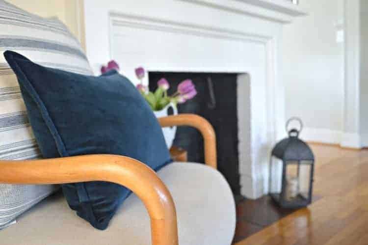 fireplace next to chair with blue pillows