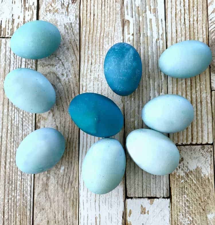 different variations of blue dyed Easter eggs on wood planks