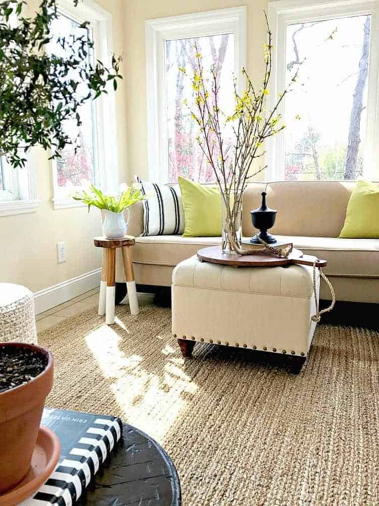 green pillows on beige sofa in sunroom