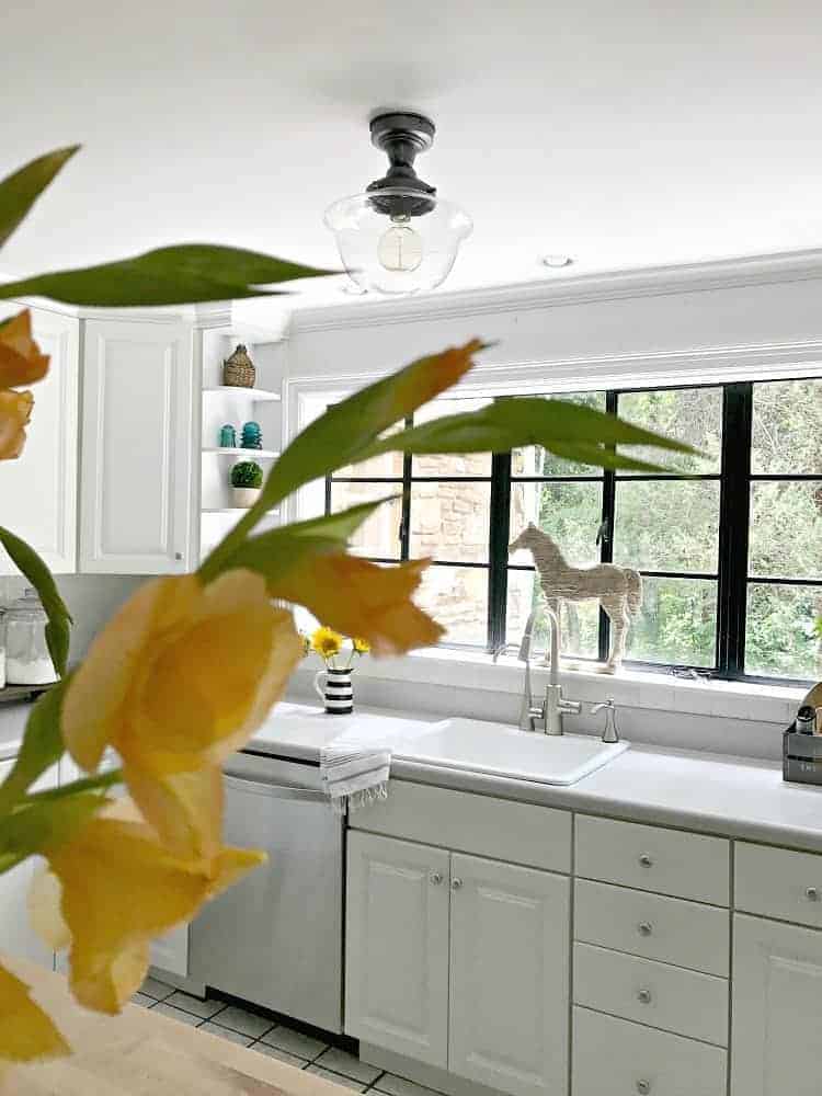 A new flush mount ceiling light fixture for a small white kitchen. 