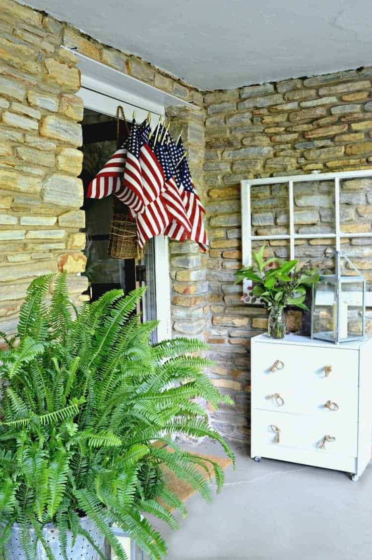 American flag display hanging on a front door of a stone house