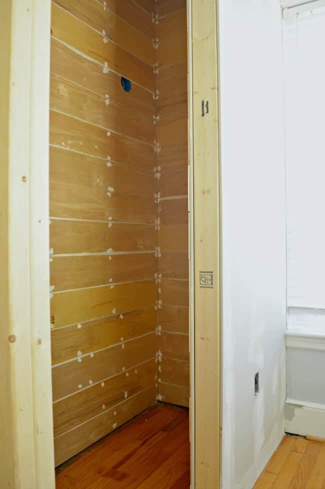 Wood planks hung and ready for paint during a small powder room build.