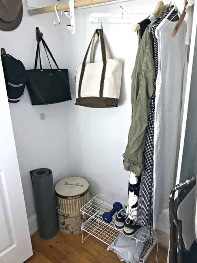 corner of bedroom closet with hat boxes and purses hanging