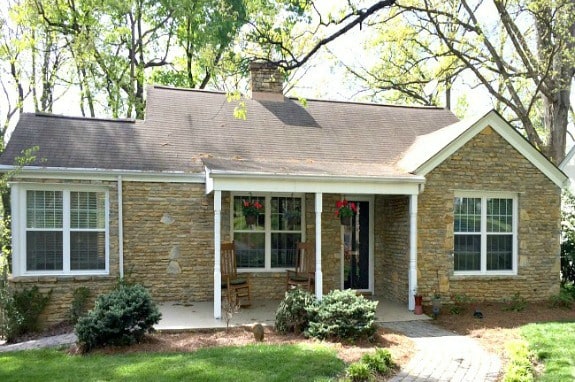 A stone house with bushes in front
