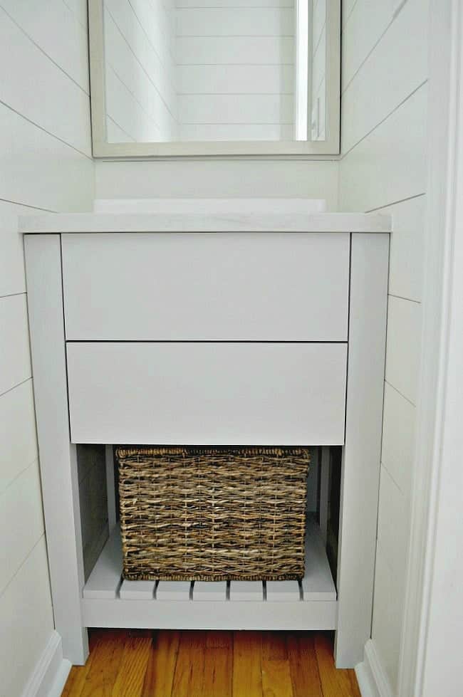 DIY vanity in guest bedroom powder room with basket on bottom shelf