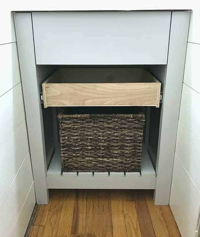 DIY powder room vanity installed before the countertop and faucet are added.