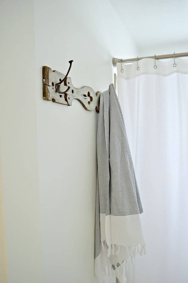 An old porch baluster turned towel holder in a bathroom.