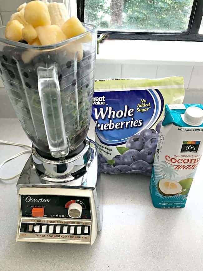 ingredients for a kale blueberry smoothie in a blender 