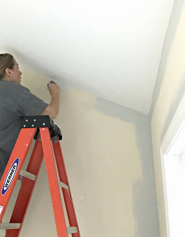 Painting the yellow walls a soft gray during a sunroom makeover.