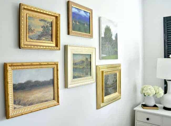 How to use thrift store art to make a gallery wall in a master bedroom. A fun way to repurpose found art from thrift stores and flea markets.