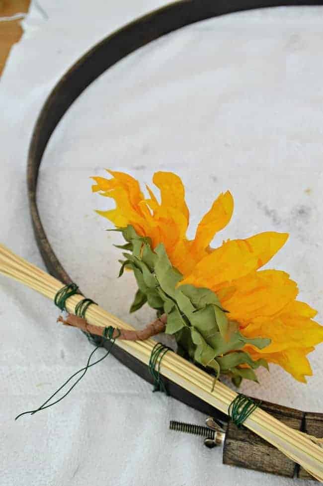 Attaching sunflowers to an embroidery hoop with floral wire to create a simple DIY fall front door wreath. 