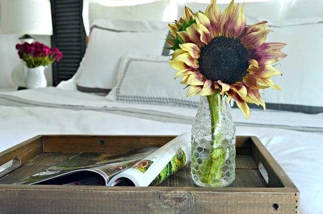 A vase of sunflowers on a bed