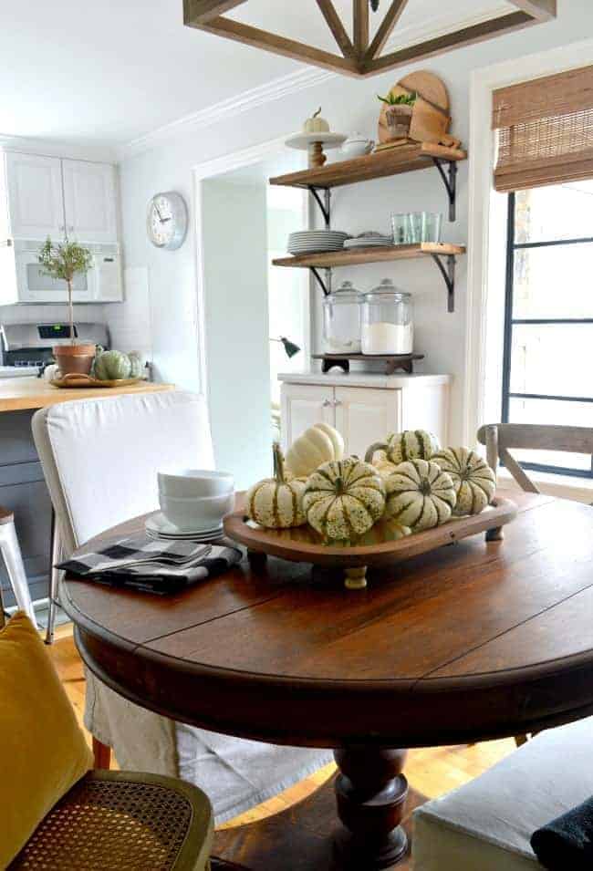 fall centerpiece with pumpkins on wood table