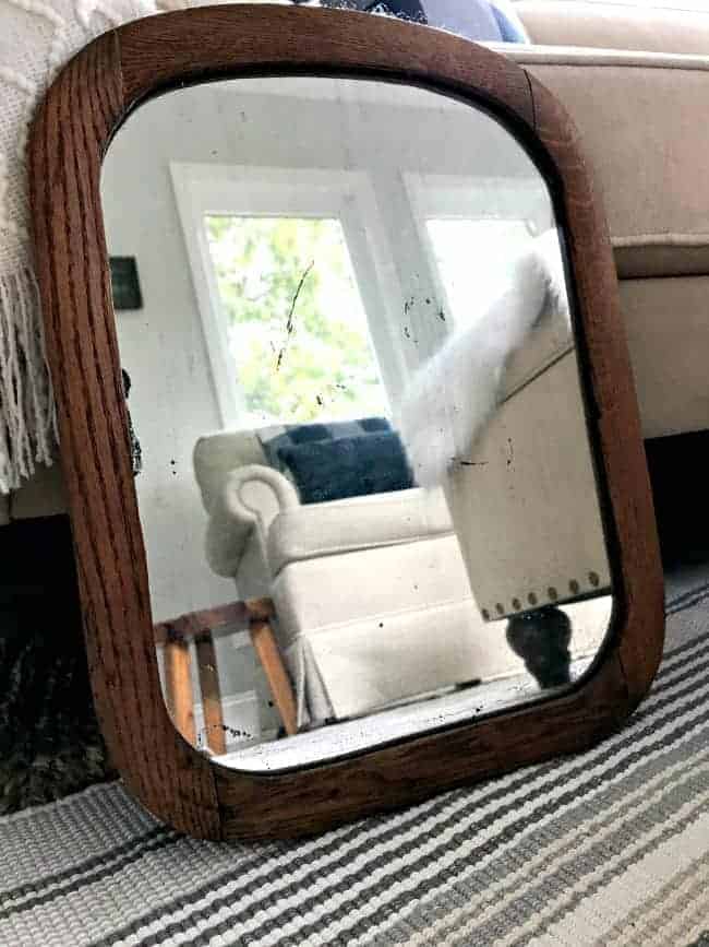 antique wood mirror, leaning against sofa