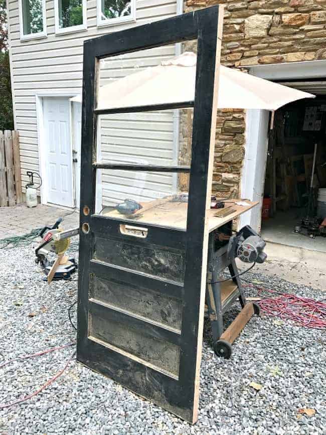black painted thrift store door leaning against a table saw