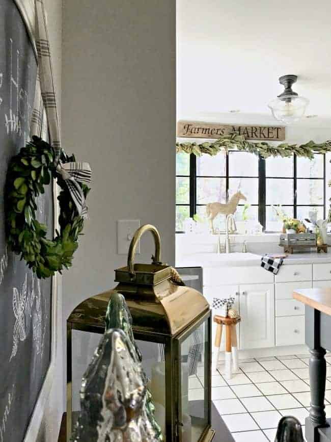 How to create a cozy cottage Christmas kitchen by using farmhouse touches like fresh greenery from the yard along with a touch of black and white.