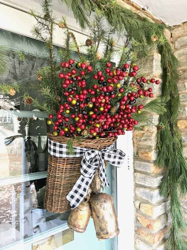 Creating a simple DIY Christmas front door basket, with bells and black buffalo check ribbon, to add holiday color to your front door.