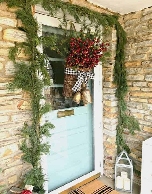 Creating a simple DIY Christmas front door basket, with berries and black buffalo check ribbon, to add holiday color and style to your front door.