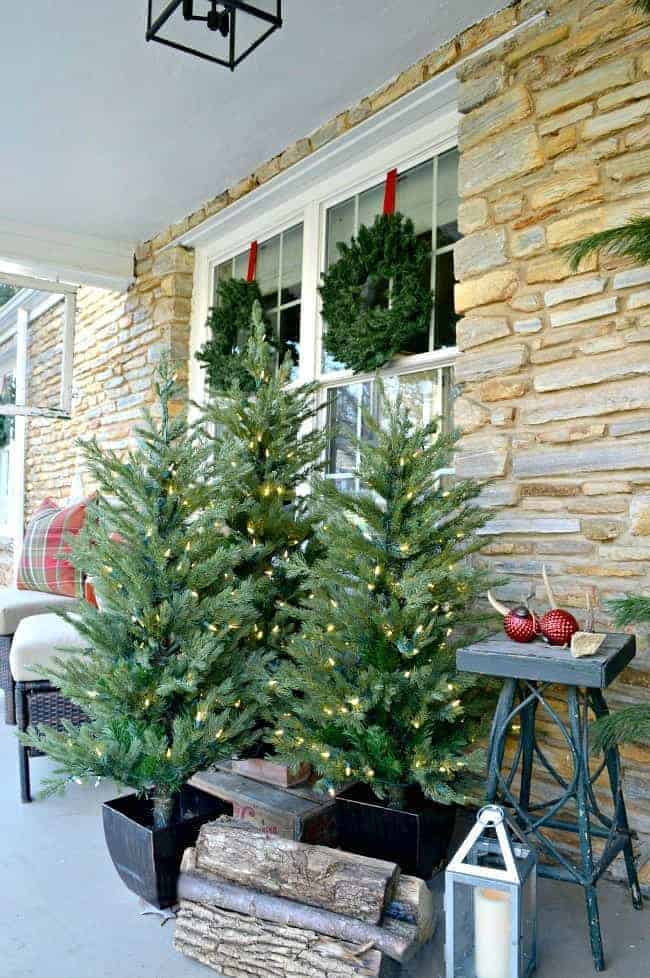 grouping of faux Christmas trees on front porch