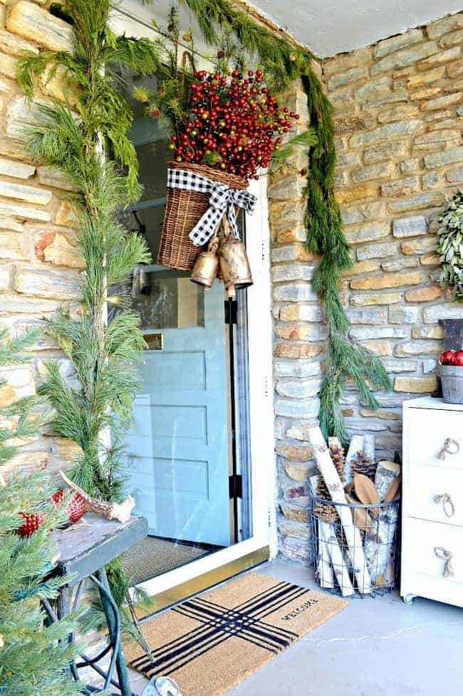 Add holiday color and style to your front door by creating a simple DIY Christmas front door basket, with berries and black buffalo check ribbon.