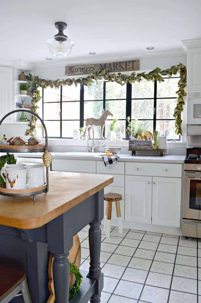 How to create a cozy cottage Christmas kitchen by using farmhouse touches like fresh greenery from the yard to make a live garland for a window.