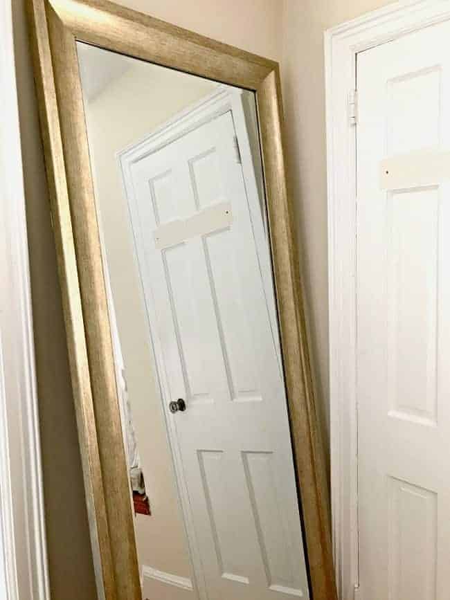 large leaning mirror with gold frame