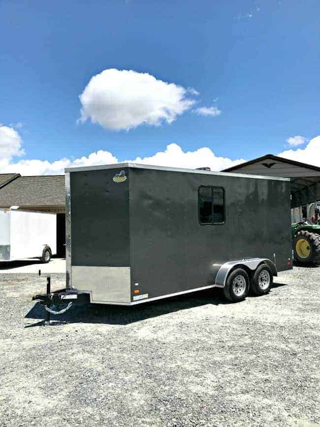 outside view of dark gray landscape trailer with window in parking lot