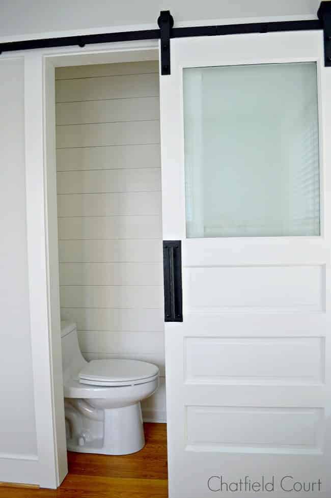 The best white paint colors and a barn door and toilet in tiny powder room