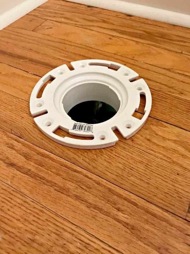 toilet bracket in hole in hardwood floor