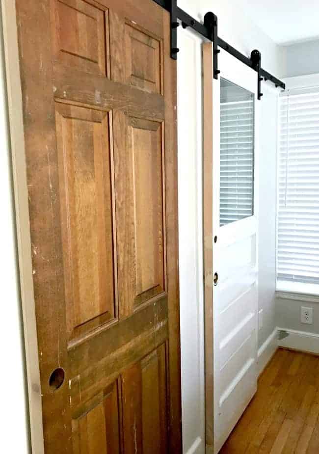 old doors hanging up on closet and bathroom barn door rail