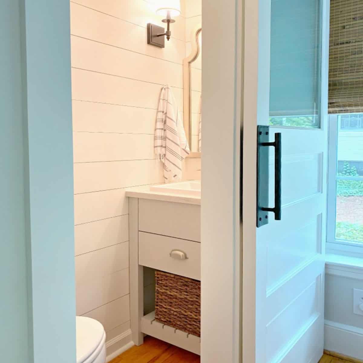 small powder room with vanity and shiplap walls