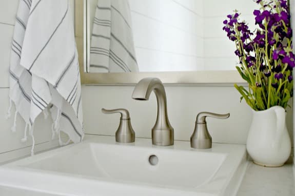 sink and purple flowers in white ceramic pitcher