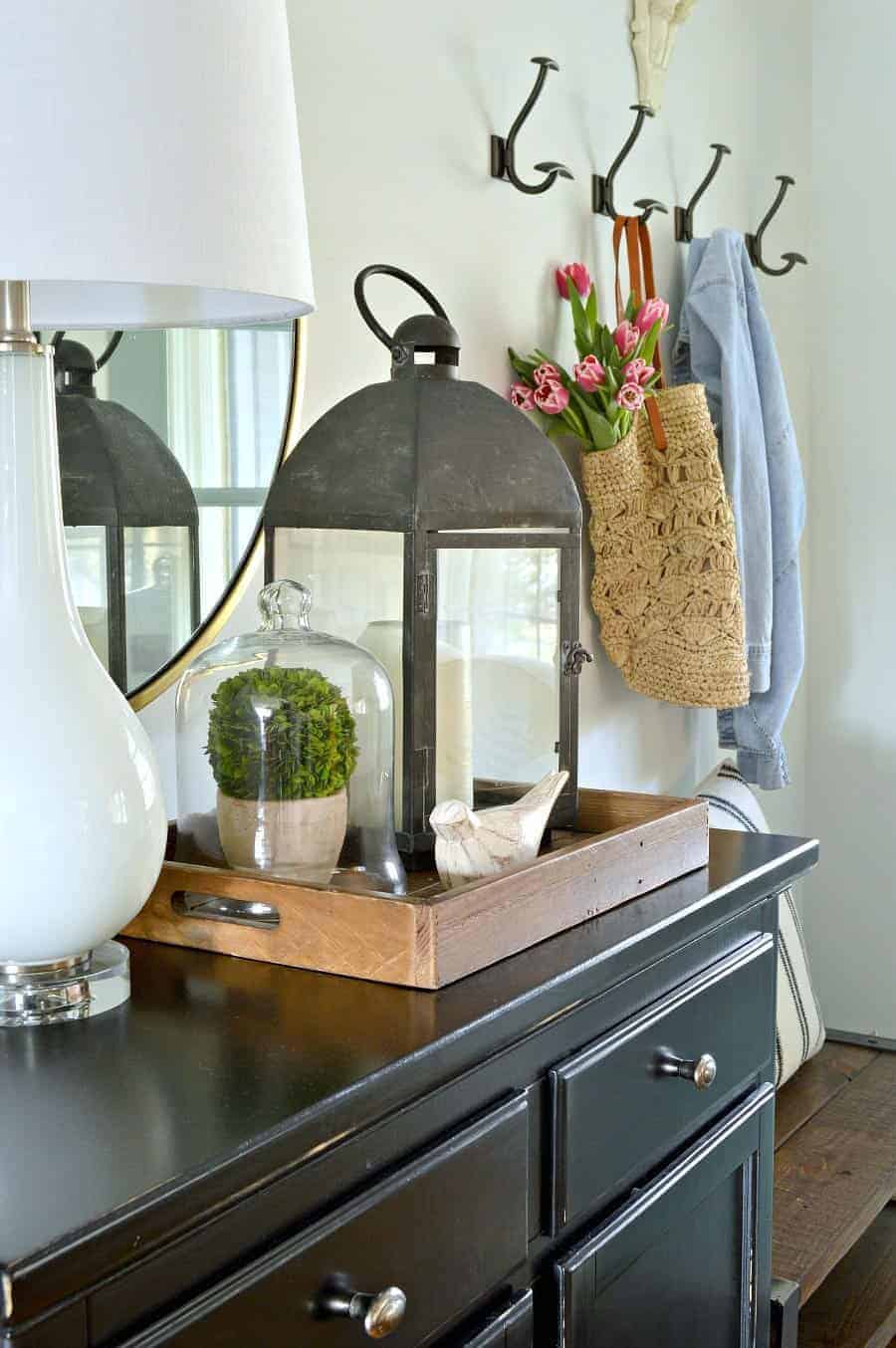small entryway with spring touches of pink tulips and preserved boxwood with a big black lantern