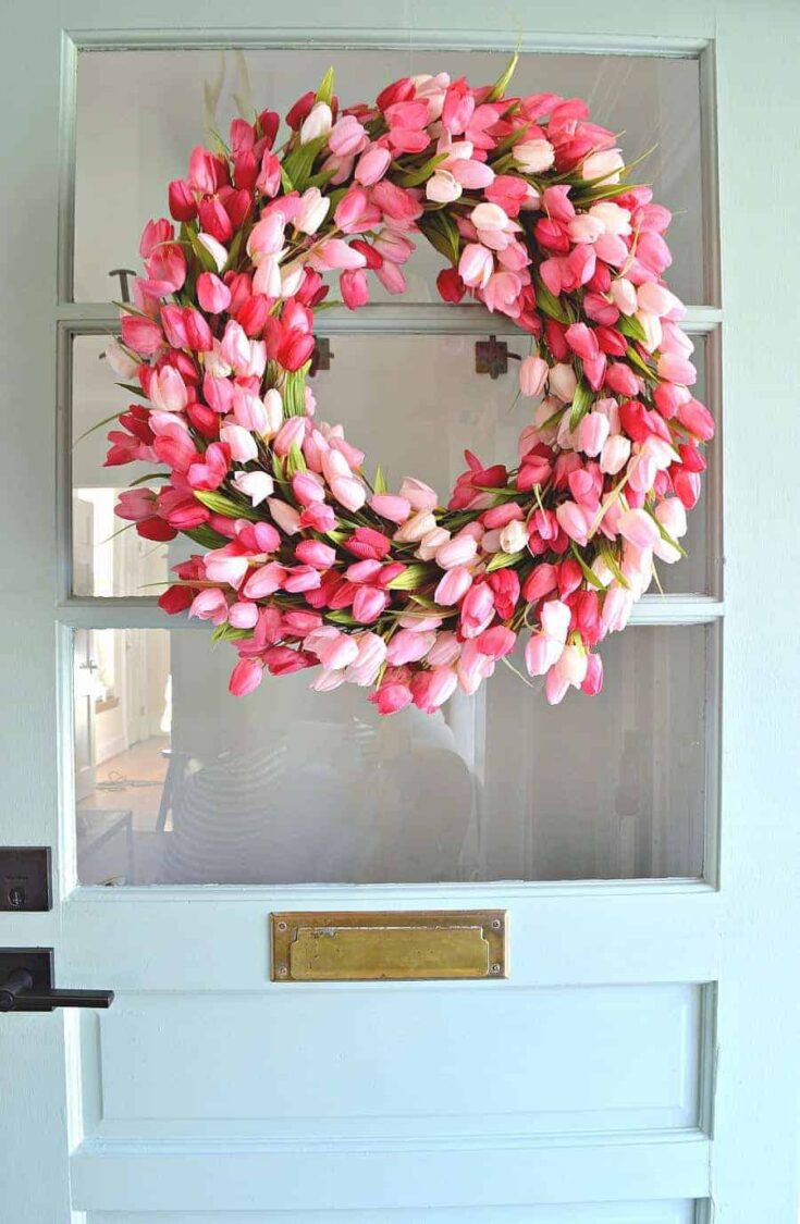 pink tulip wreath hanging on front door