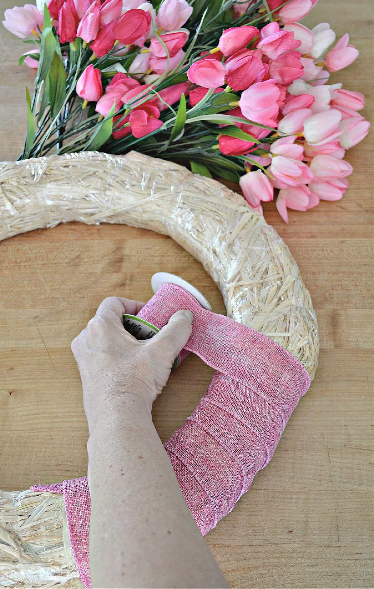 wrapping straw wreath form with pink ribbon