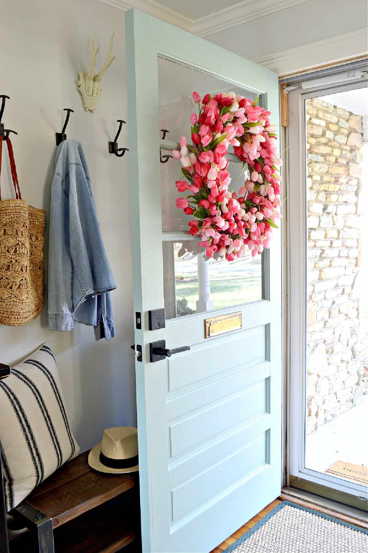 pink tulip wreath on blue front door