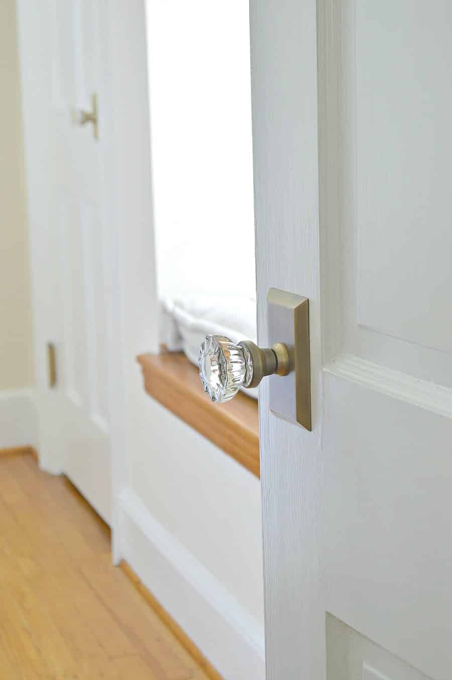  glass and antique brass door knob on old wooden white door