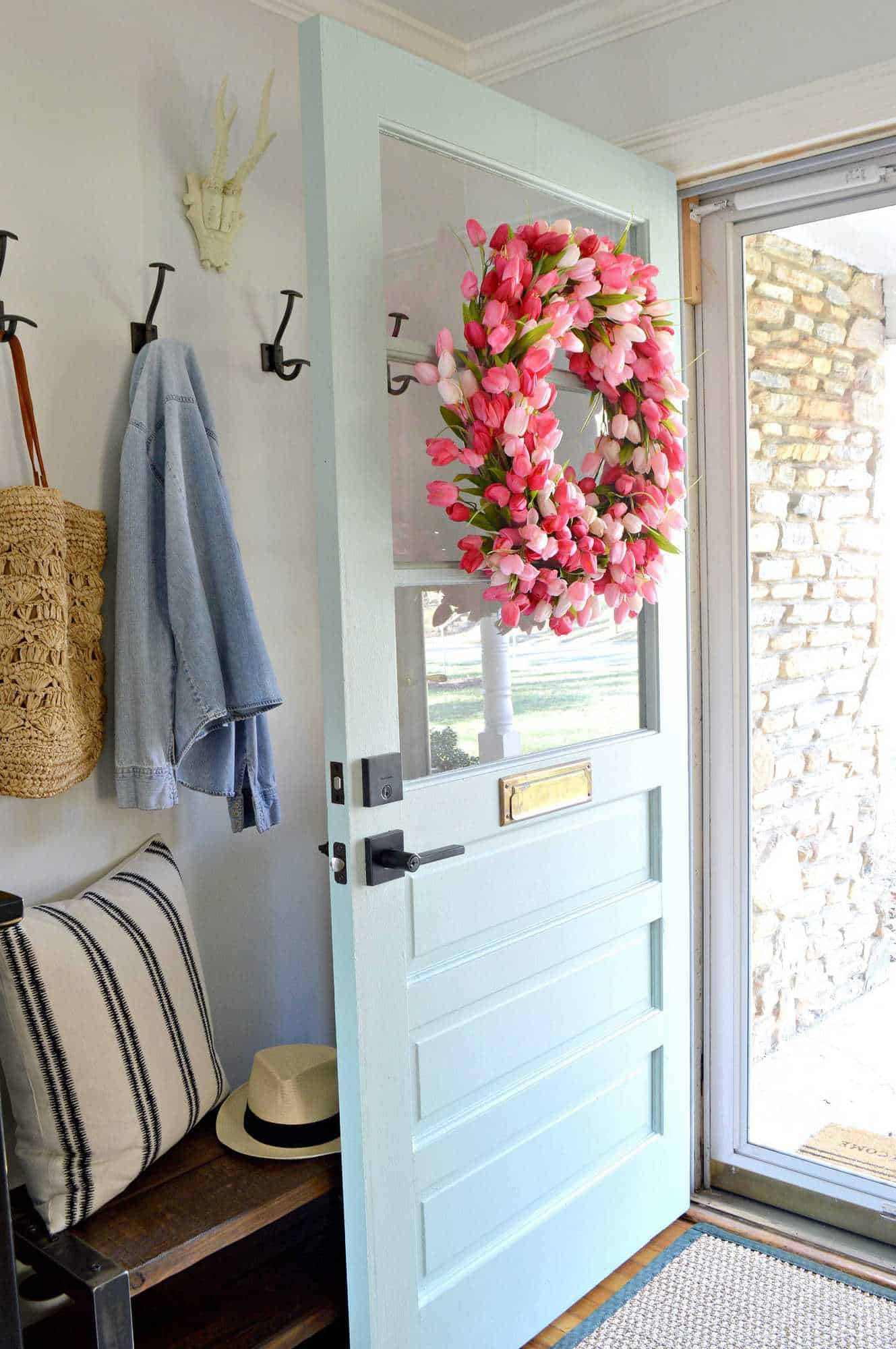 DIY pink tulip wreath on light blue farmhouse front door