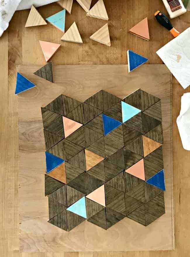 stained and painted wood triangles arranged in a square shape