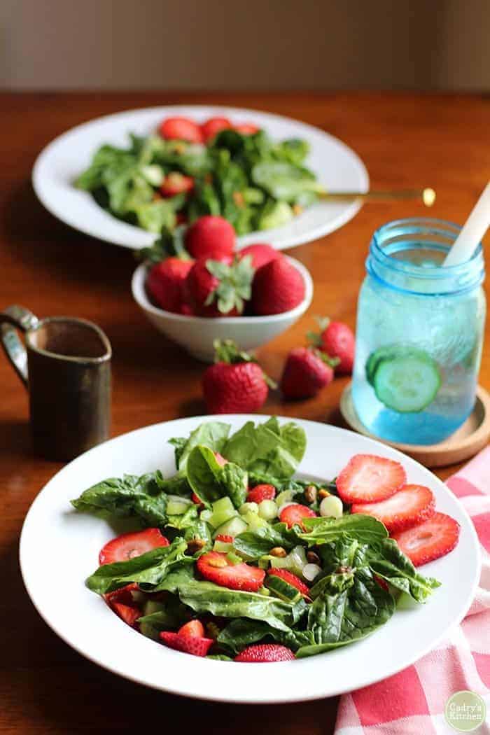 a spinach salad with strawberries that is part of the 15 cold summer salads
