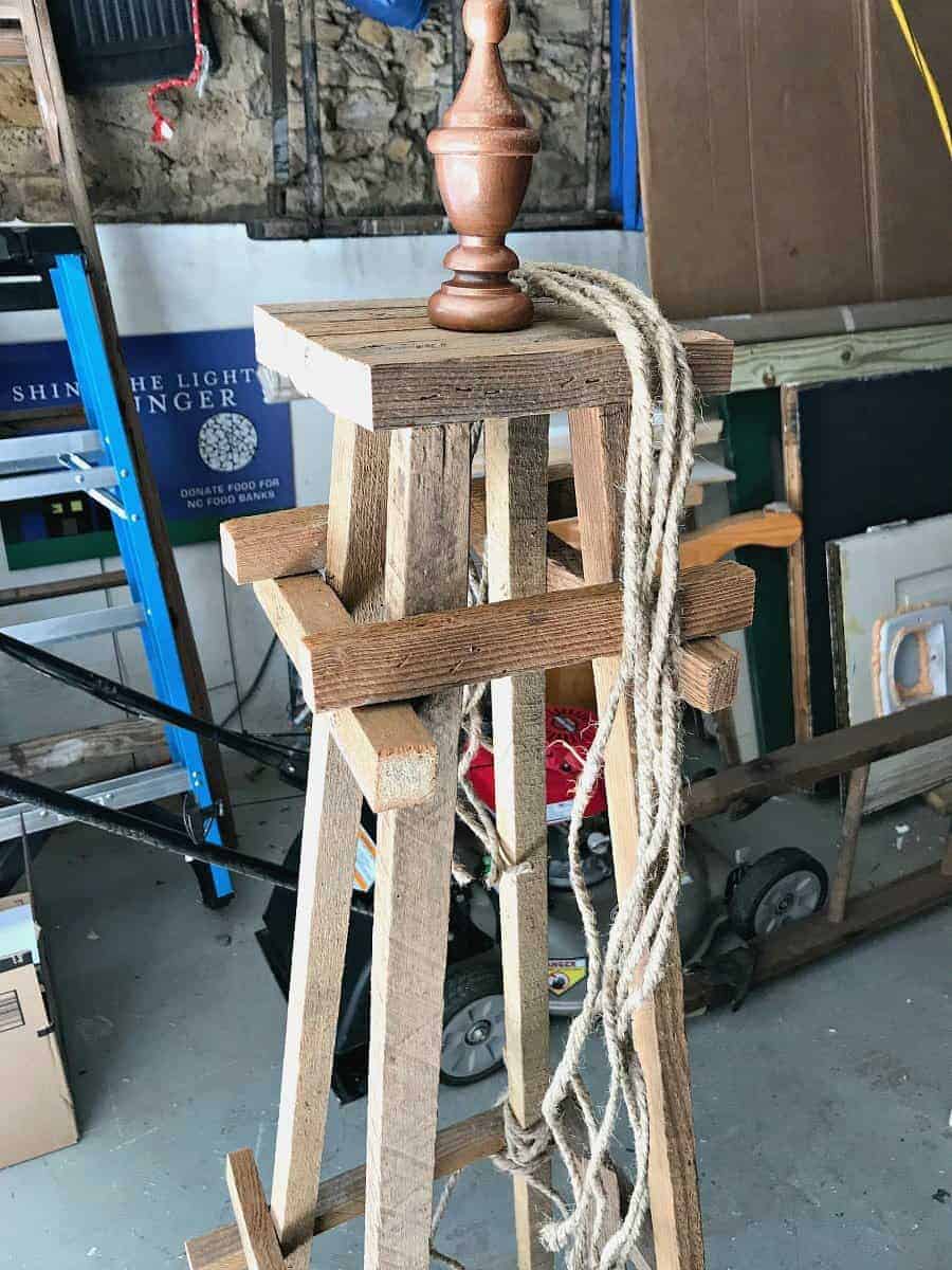 jute twine lengths sitting on the top of a wooden garden obelisk