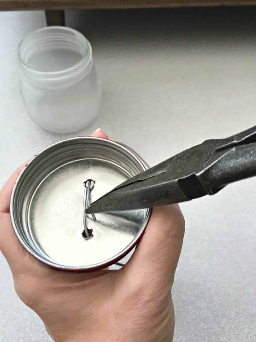 making DIY mason jar lanterns, bending wire in jar lid to create a handle