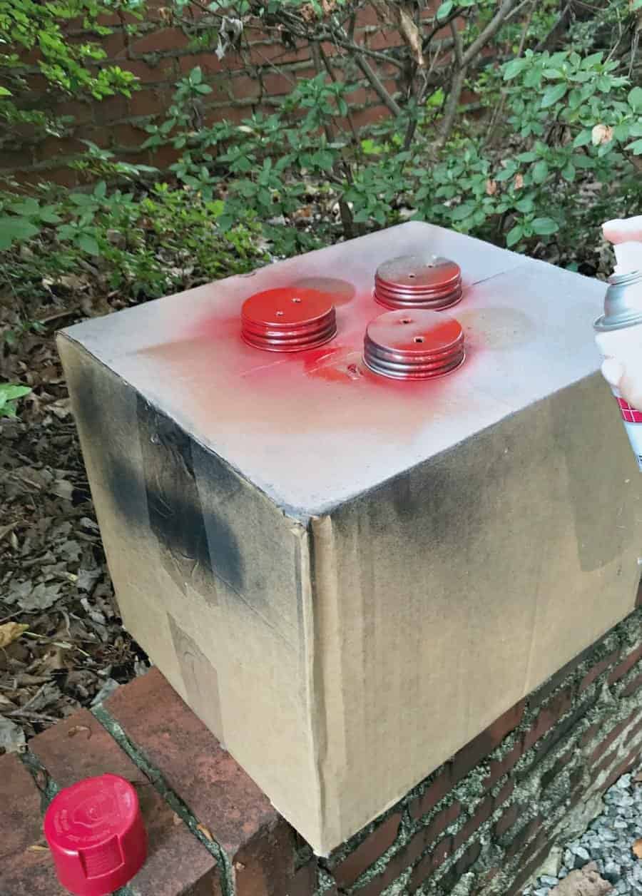 making DIY mason jar lanterns, spray painting mason jar lids red